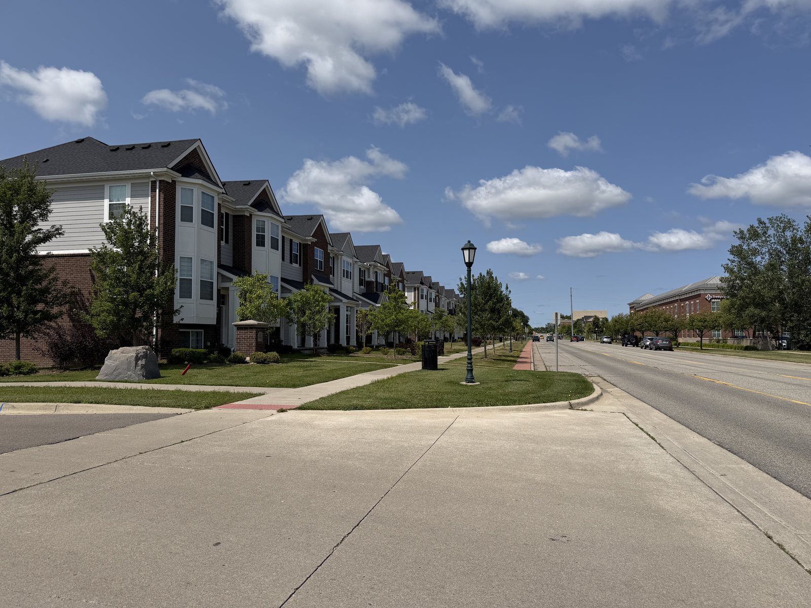 Townhomes and a sidewalk along a Cherry Hill Village street in Canton, Michigan.
