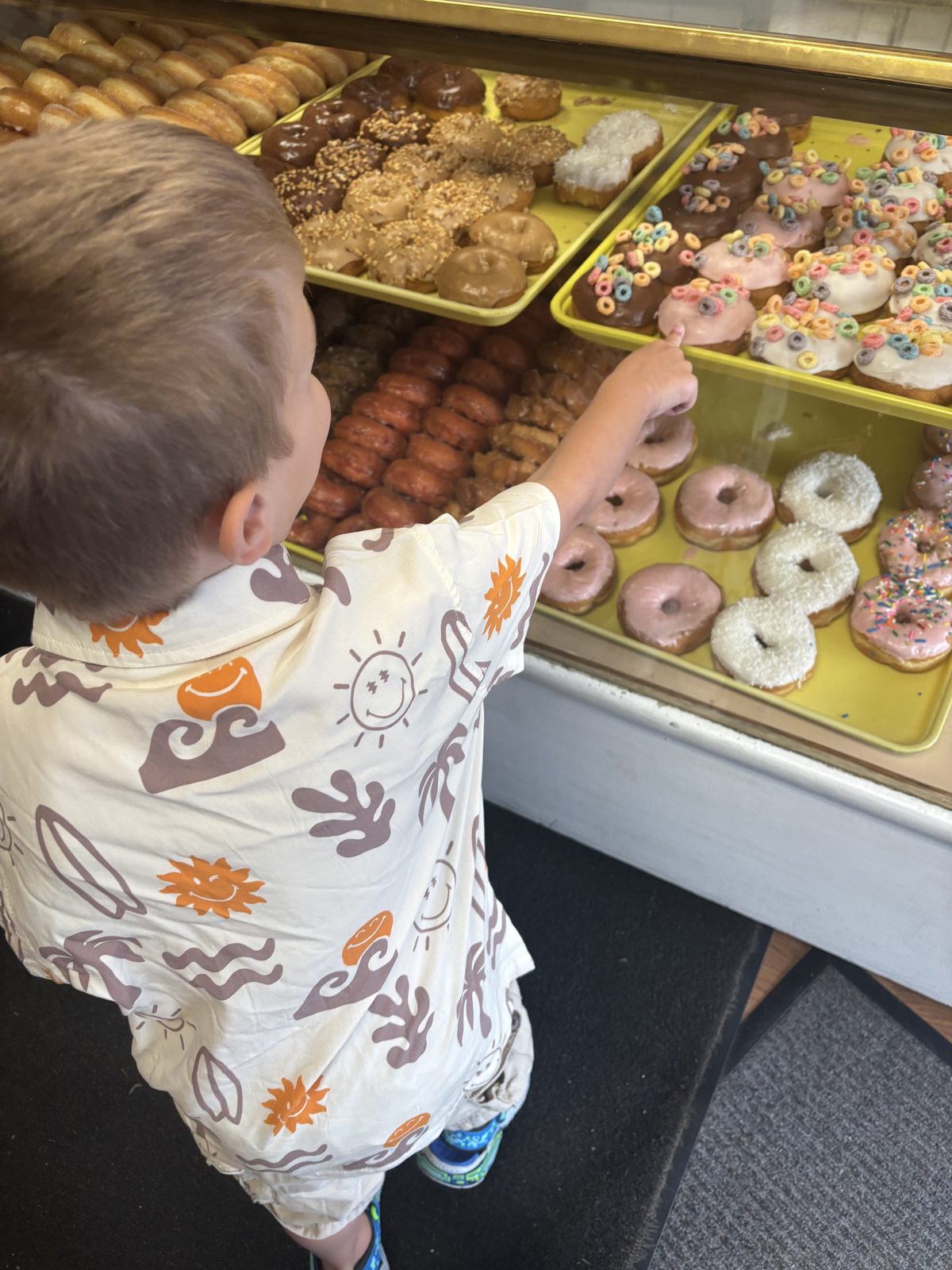 A child pointing to a donut in the display case at South Lyon Village Bakery in downtown South Lyon, Michigan.