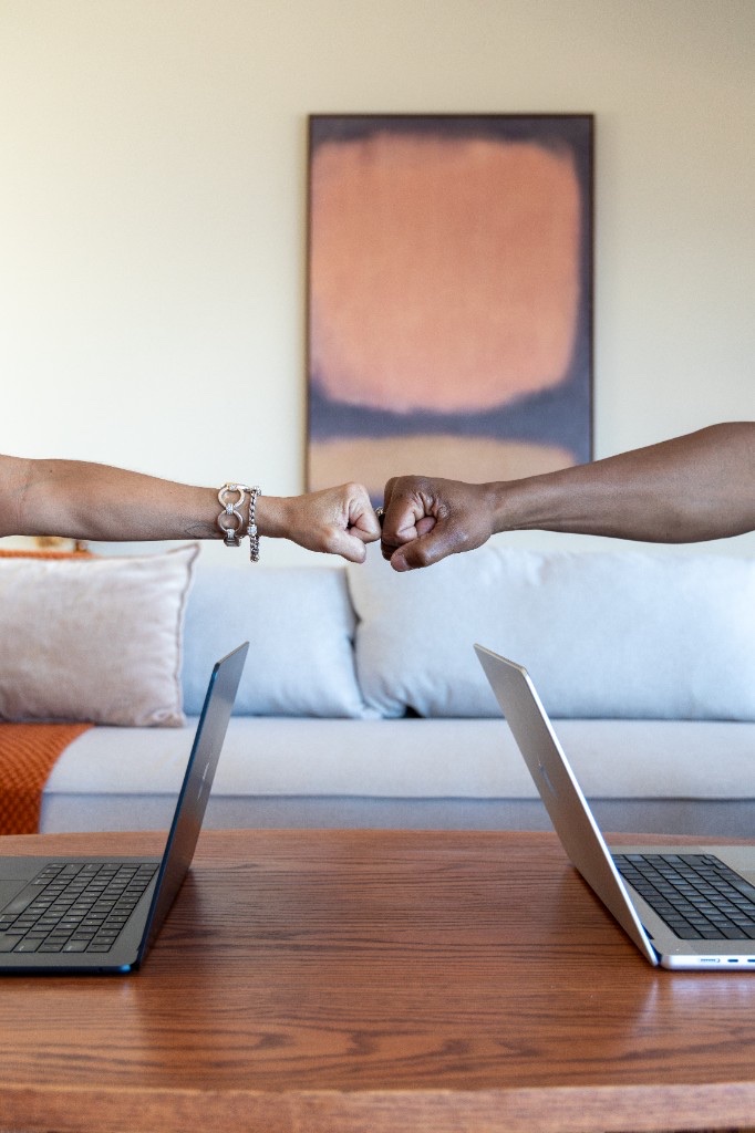 Derica Wade and Leonard Wade sharing a fist bump across a table while collaborating on a client decision