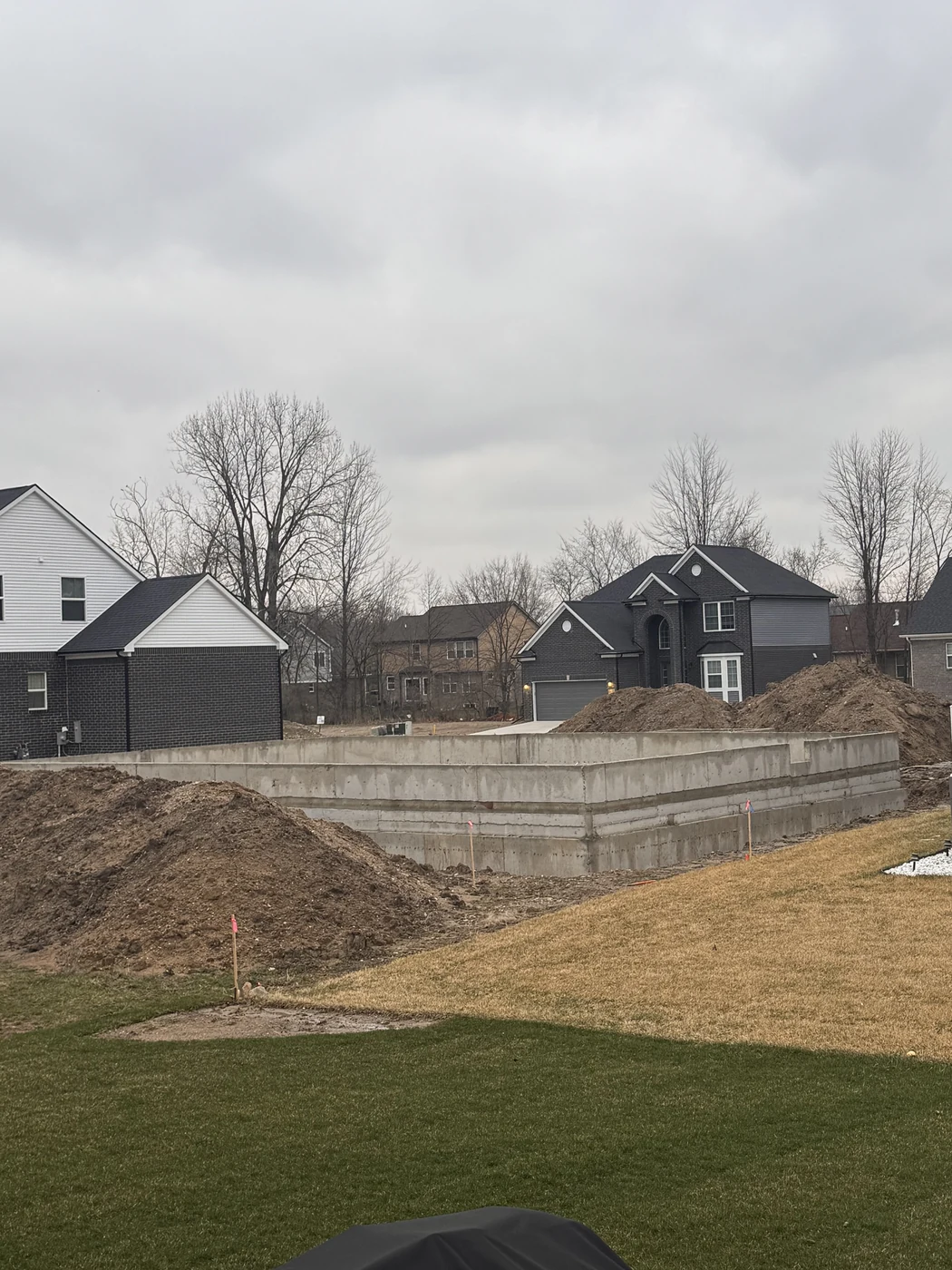 Fresh concrete being poured into foundation forms to create basement walls on a new construction site