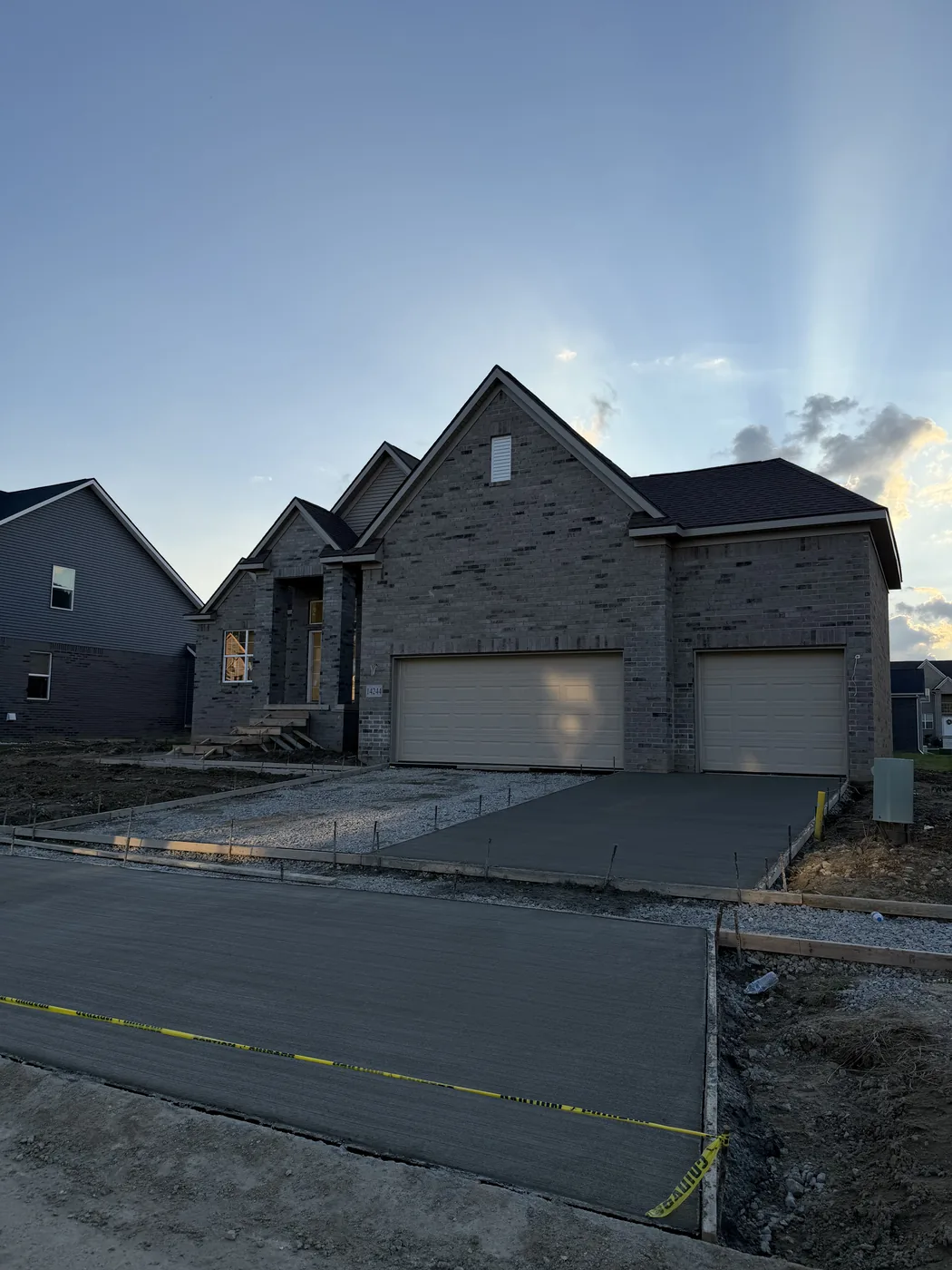 Exterior of a new construction home with completed brick veneer, finished roof, and landscaping in place