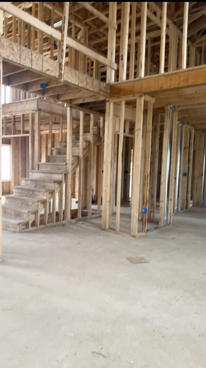 Interior view of a new construction home showing wood wall framing and room layout before drywall is installed