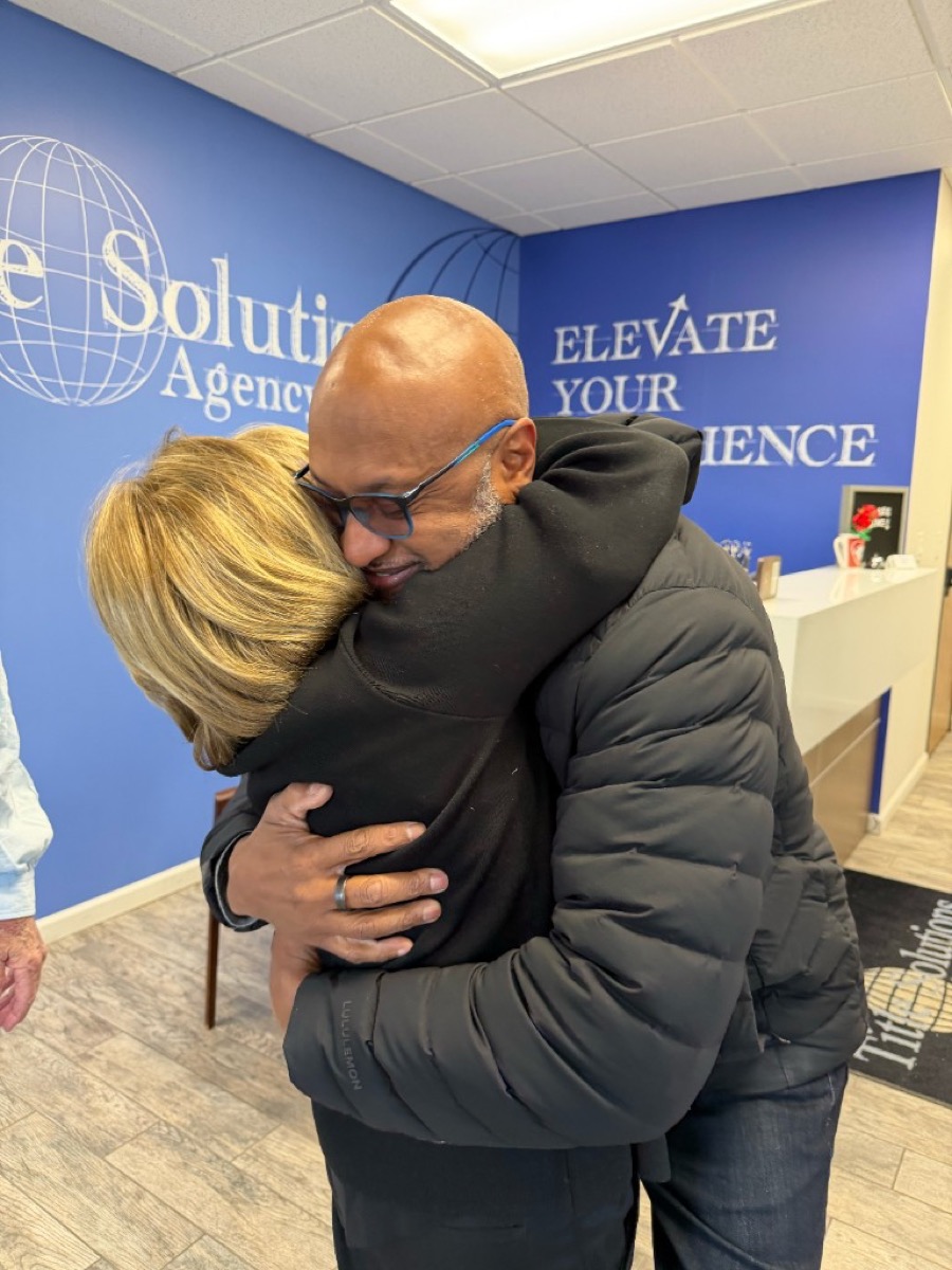 Hearts to Homes clients embracing their real estate agent after a successful Michigan home closing at a title agency