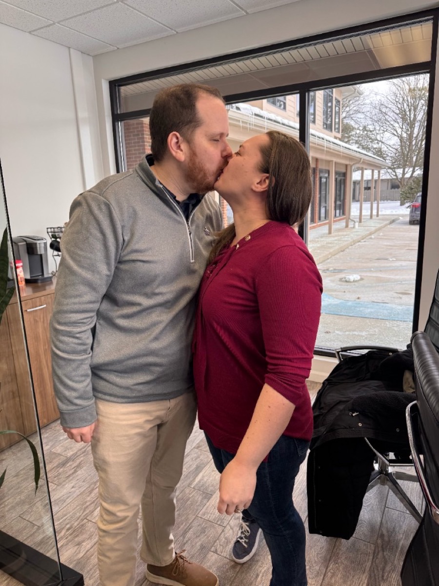 Michigan home buyers celebrating together after signing closing documents at a title company
