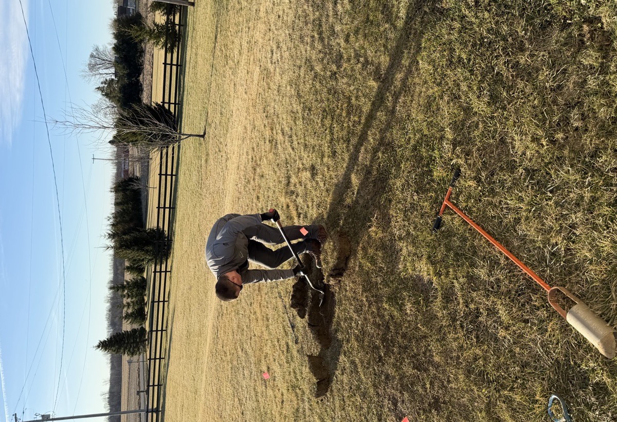 Septic system inspector evaluating a drain field during a specialty inspection at a rural Southeast Michigan property