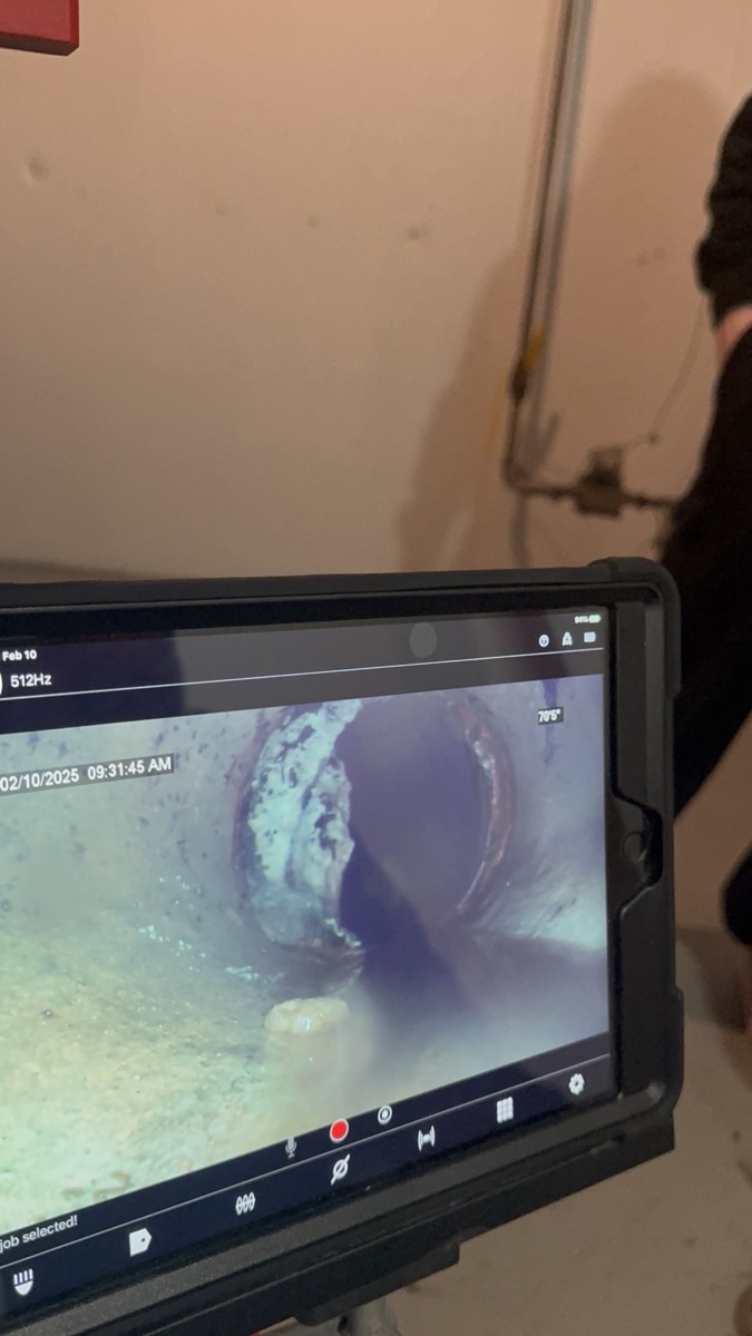 Tablet displaying a clean sewer scope camera view during a sewer line inspection at a Michigan home